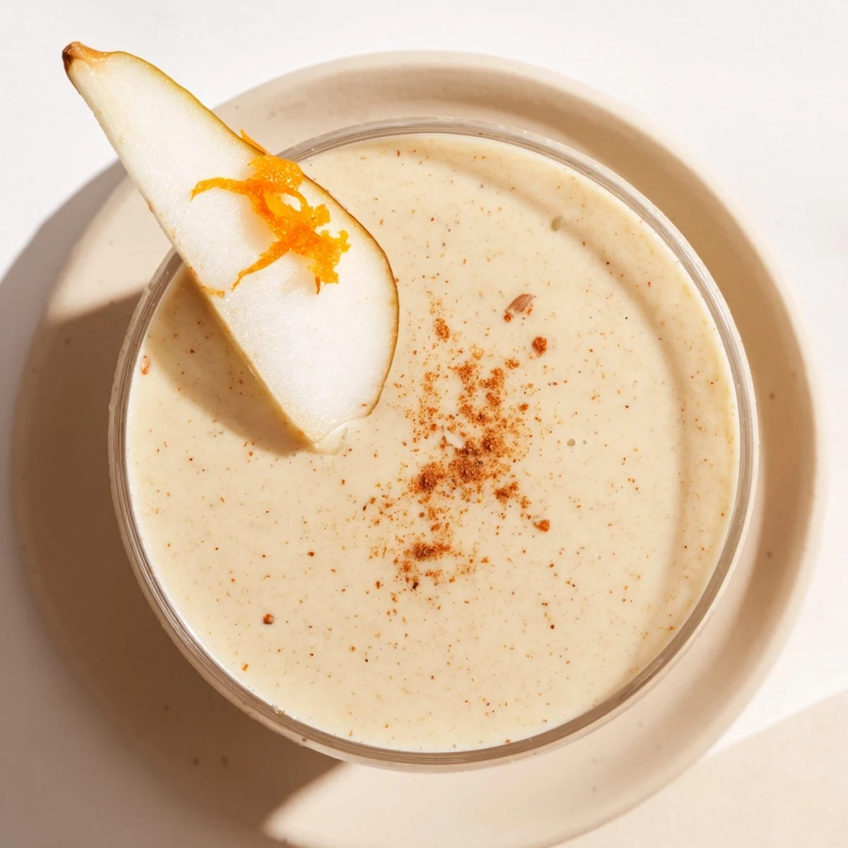 Vibrant photo of a Festive Pear Smoothie with a thick texture and fresh orange segments visible.