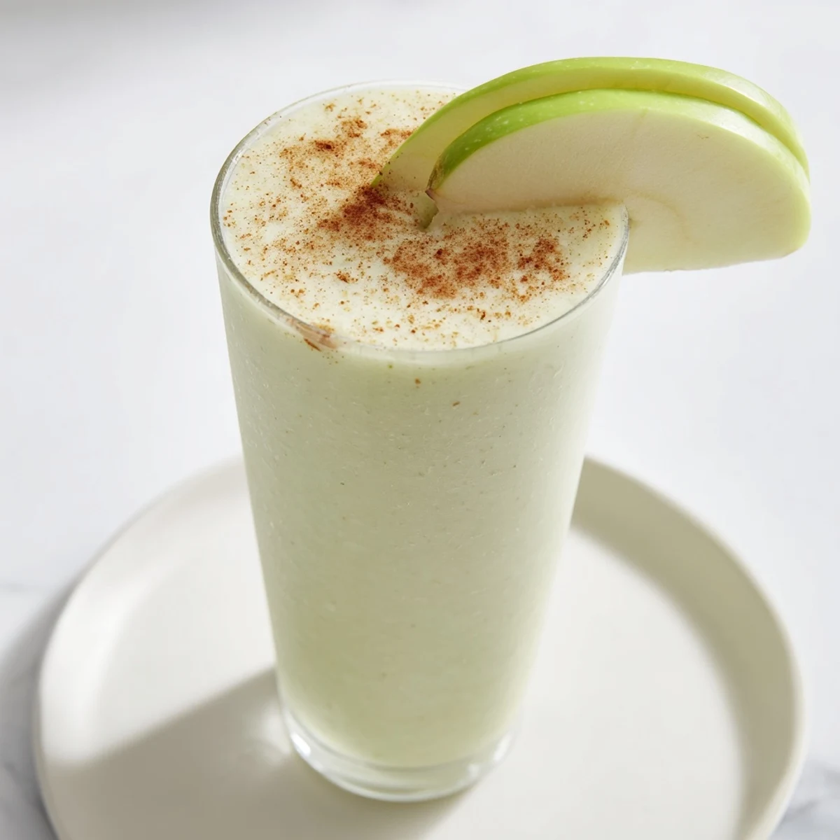 Delicious Crisp Apple Smoothie swirled in a glass, suggesting the fresh flavor of Granny Smith apples.