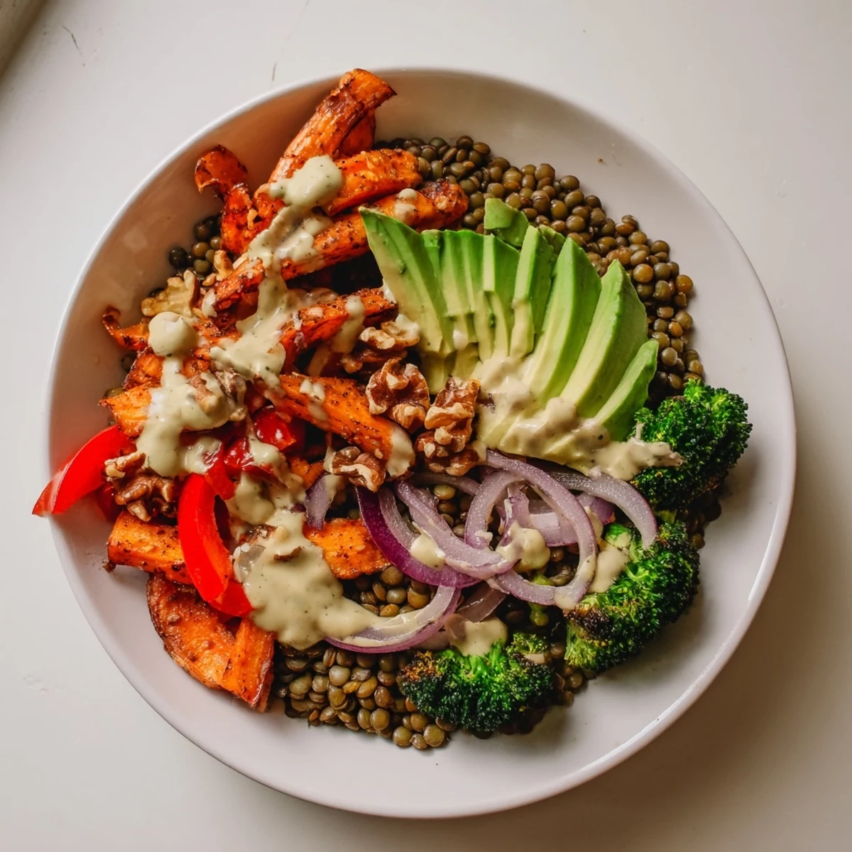 A colorful Wholesome Lentil Bowl with roasted vegetables and creamy tahini dressing, delicious.