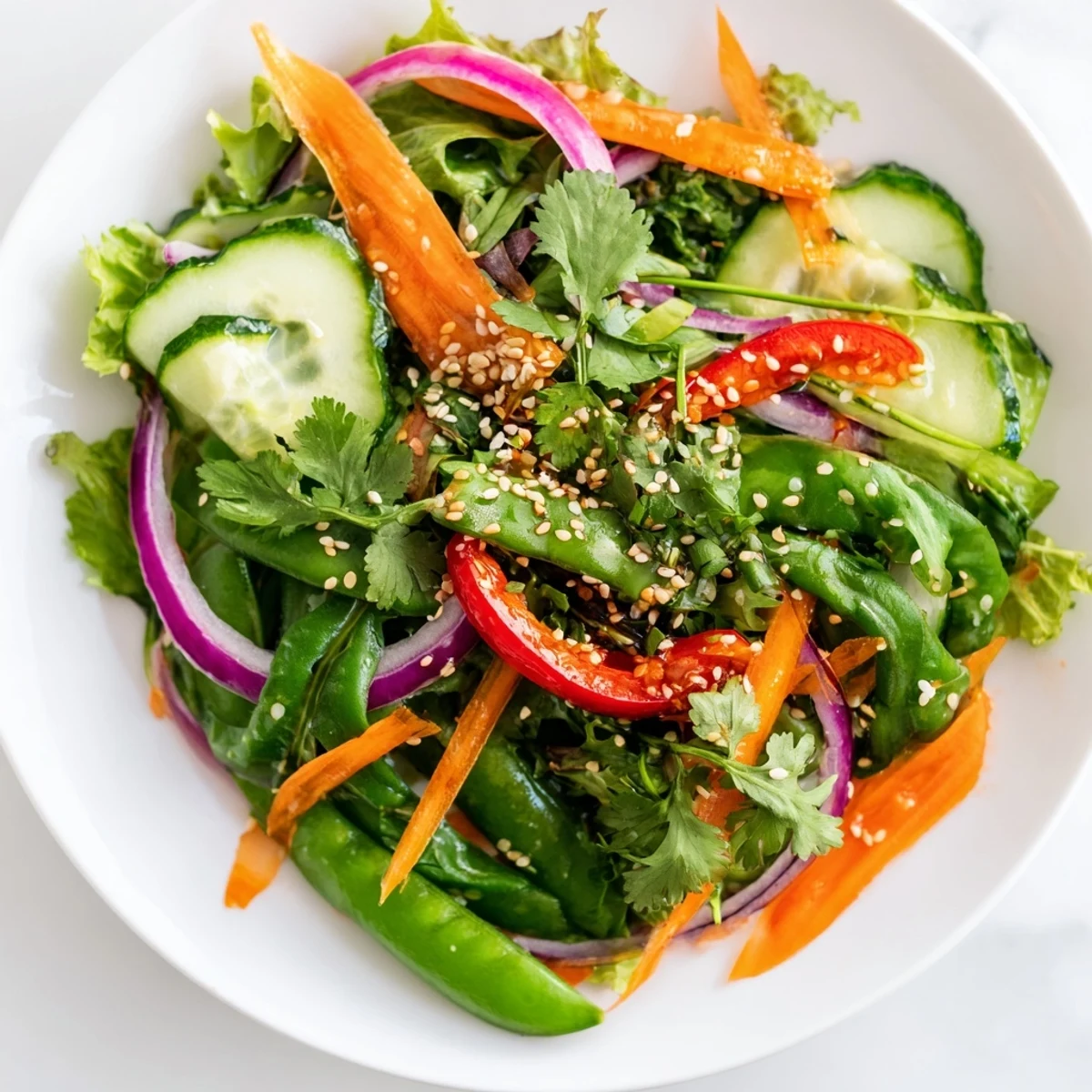 Fresh Crisp Ginger Salad garnished with sesame seeds and cilantro, served as a light, crunchy Asian-inspired side.