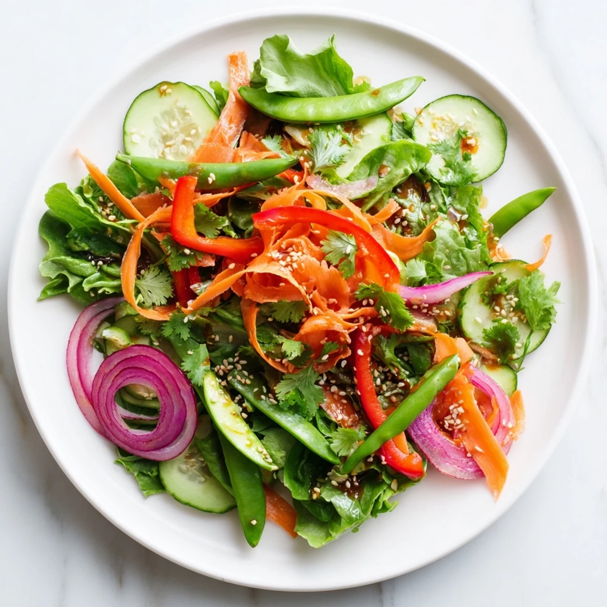 Bright Crisp Ginger Salad with snap peas and cucumber tossed in a ginger-lime dressing on a rustic table.