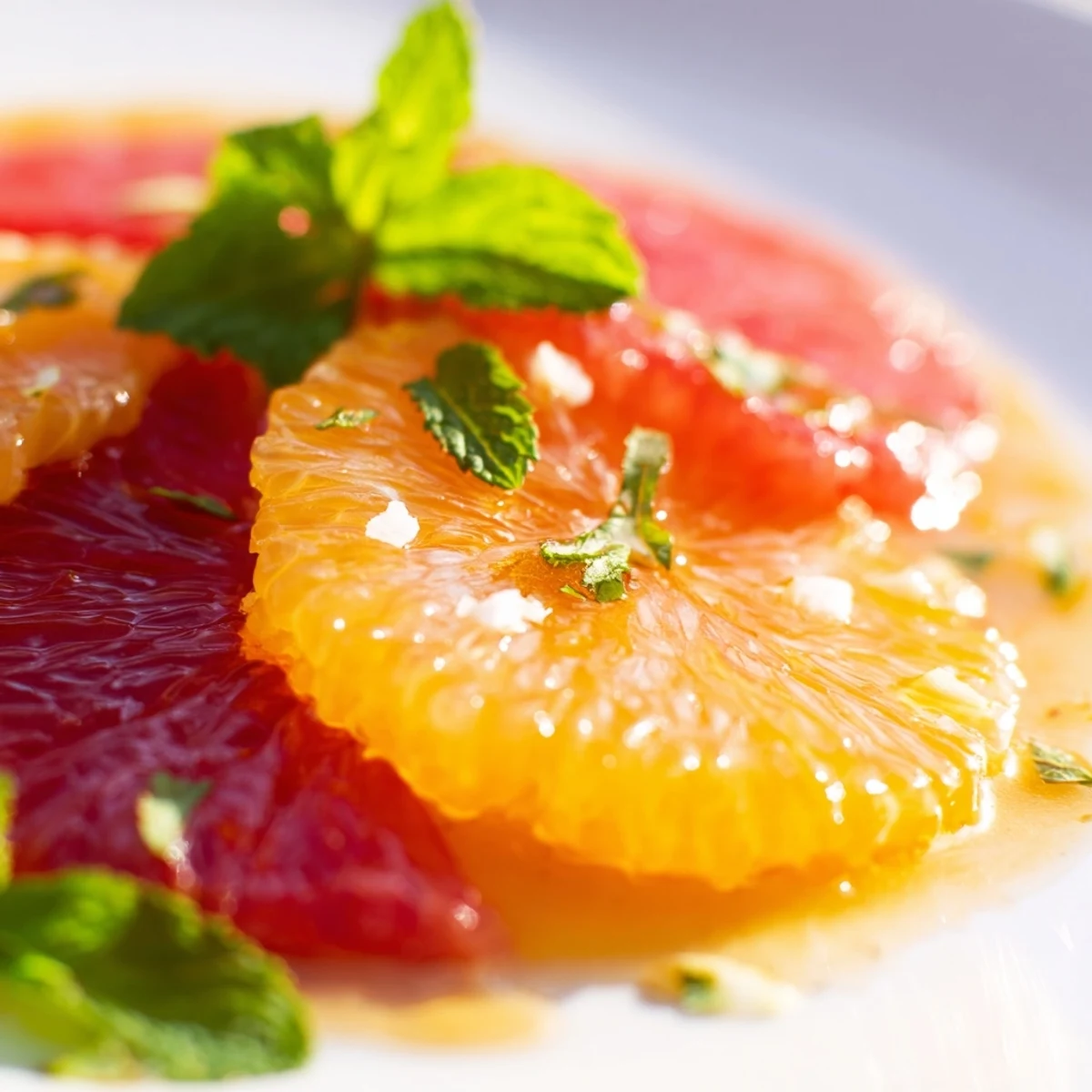 Colorful Fresh Citrus Salad in a wide shallow bowl with fresh mint, showcasing juicy citrus rounds for a refreshing healthy dessert.