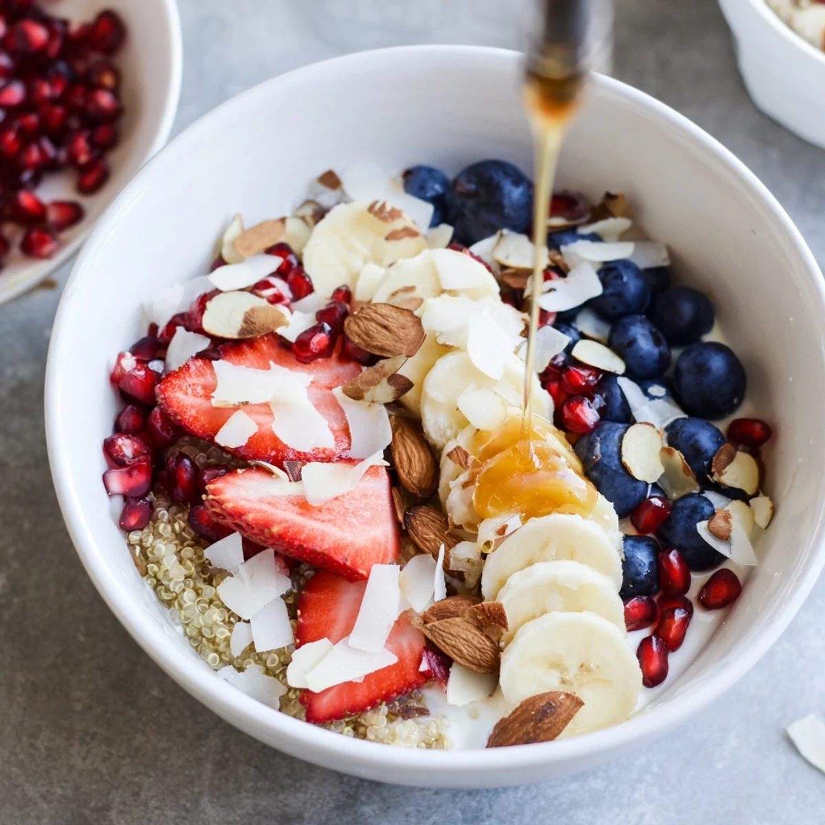 Vibrant Frosted Quinoa Bowl topped with Greek yogurt, fresh strawberries, blueberries, and banana slices.