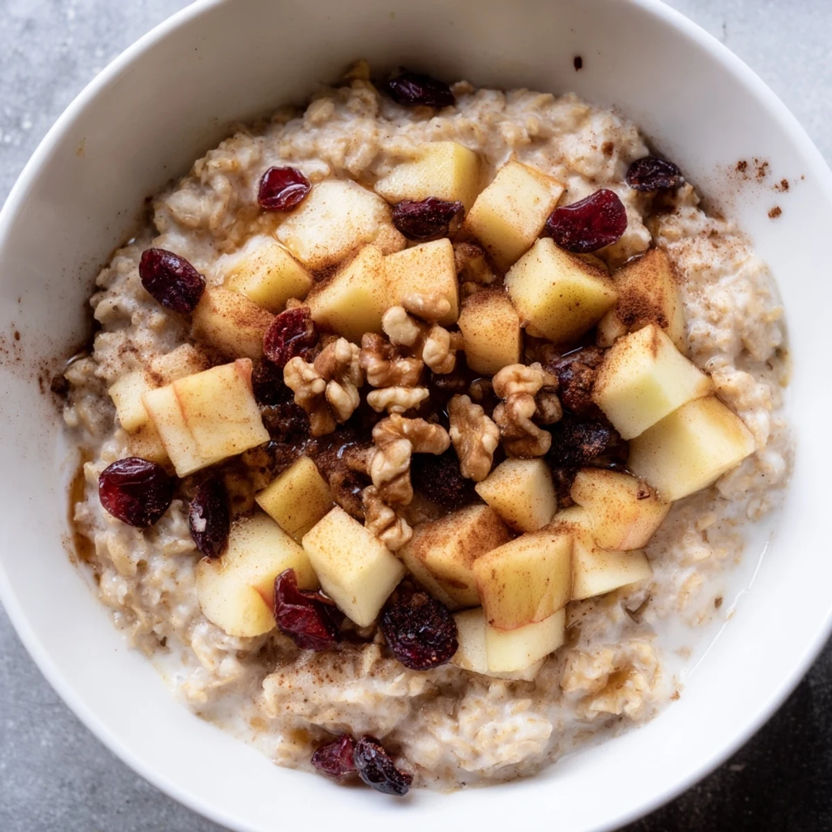 Overhead view of Warm Apple Porridge showing thick oatmeal texture with warm spices and maple syrup.