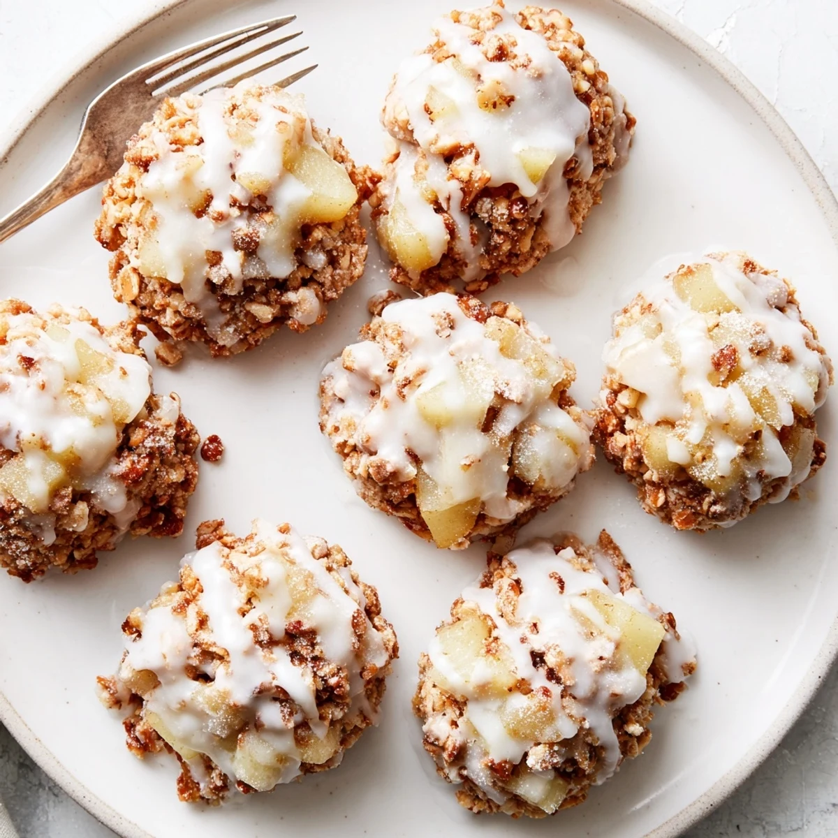 A close-up of golden Frosted Pear Clusters featuring diced pears, toasted nuts, and oats on a rustic wooden board.