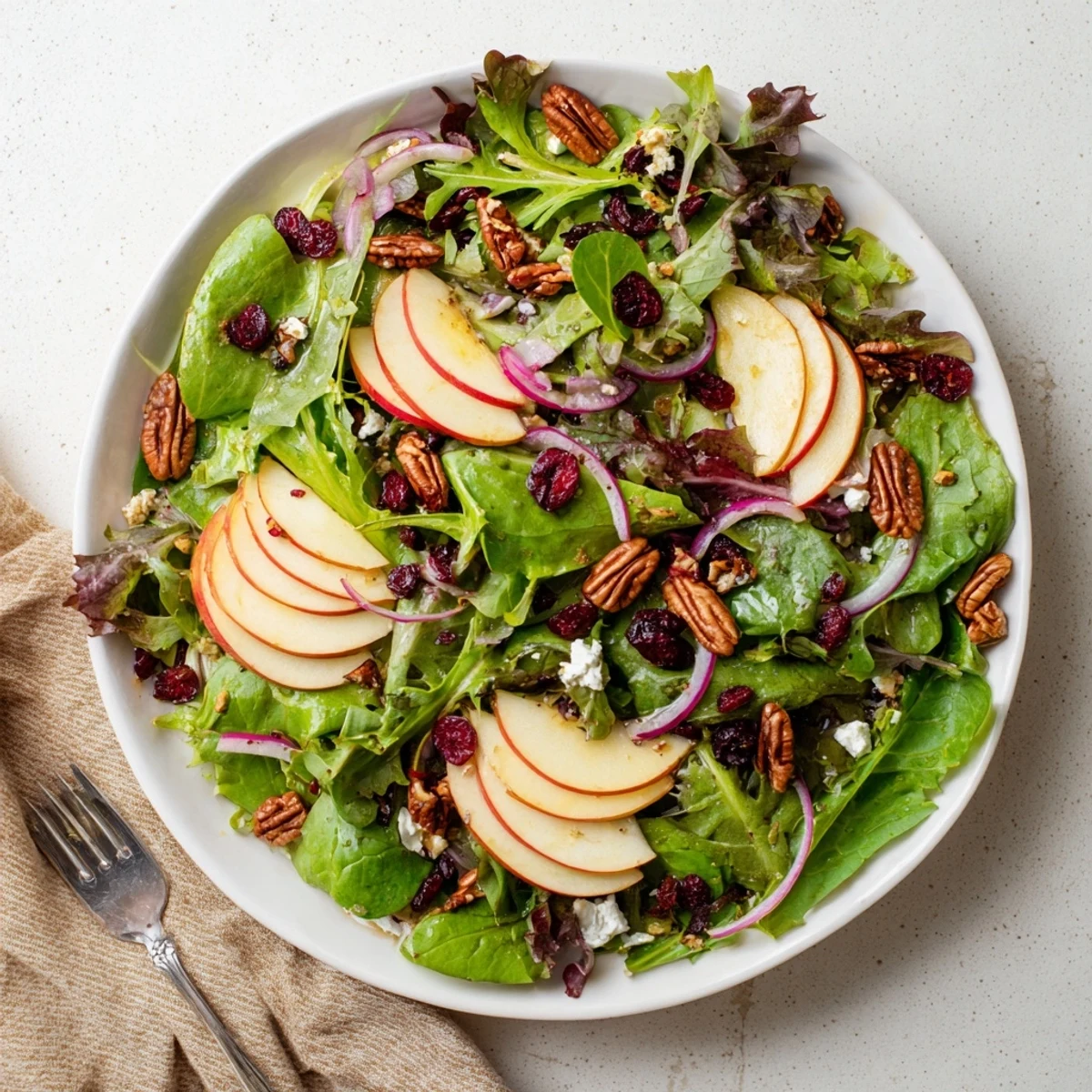 Crisp Maple Salad in a white bowl featuring crunchy celery, red onion, dried cranberries, and a glossy maple dressing ready for a quick fall lunch.