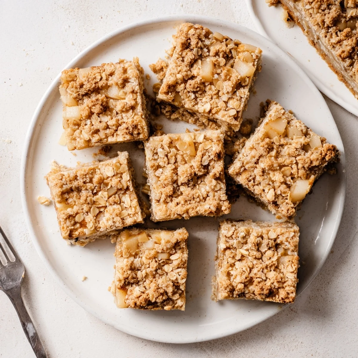 Warm Wholesome Pear Bars with cinnamon-spiced oats, presented on a baking sheet with fresh pear slices and maple syrup drizzle.