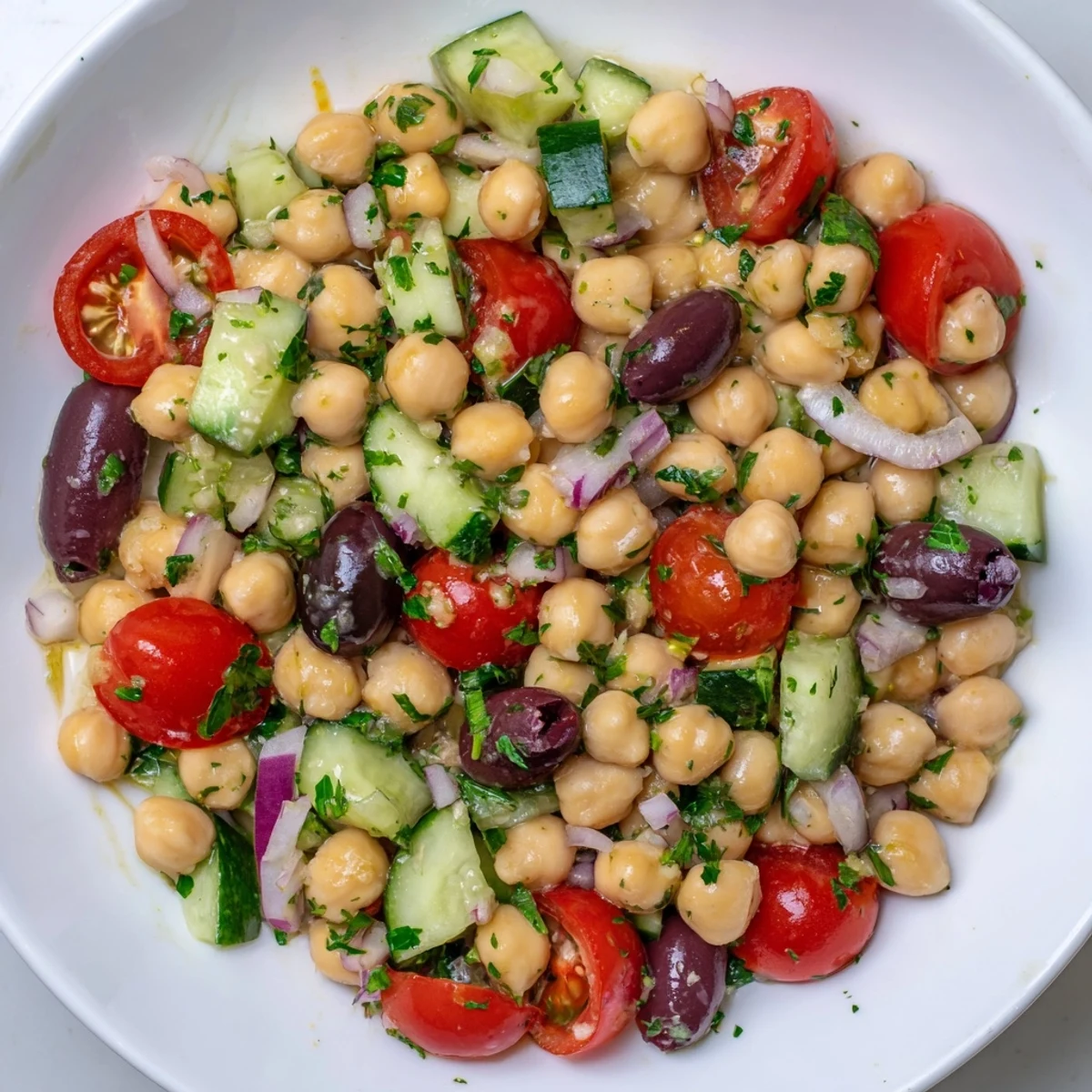 Vegan Chickpea Salad served over crisp greens with Kalamata olives, perfect for quick meal prep or a healthy potluck dish.