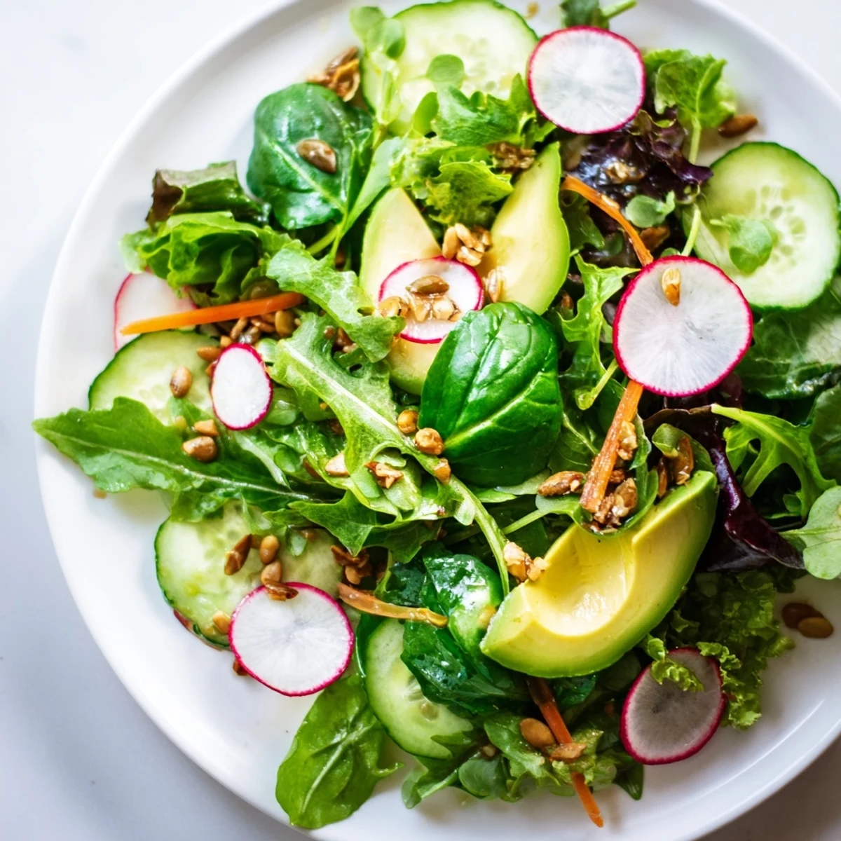 Seasonal Green Salad served in a rustic bowl, topped with avocado slices and toasted pumpkin seeds.