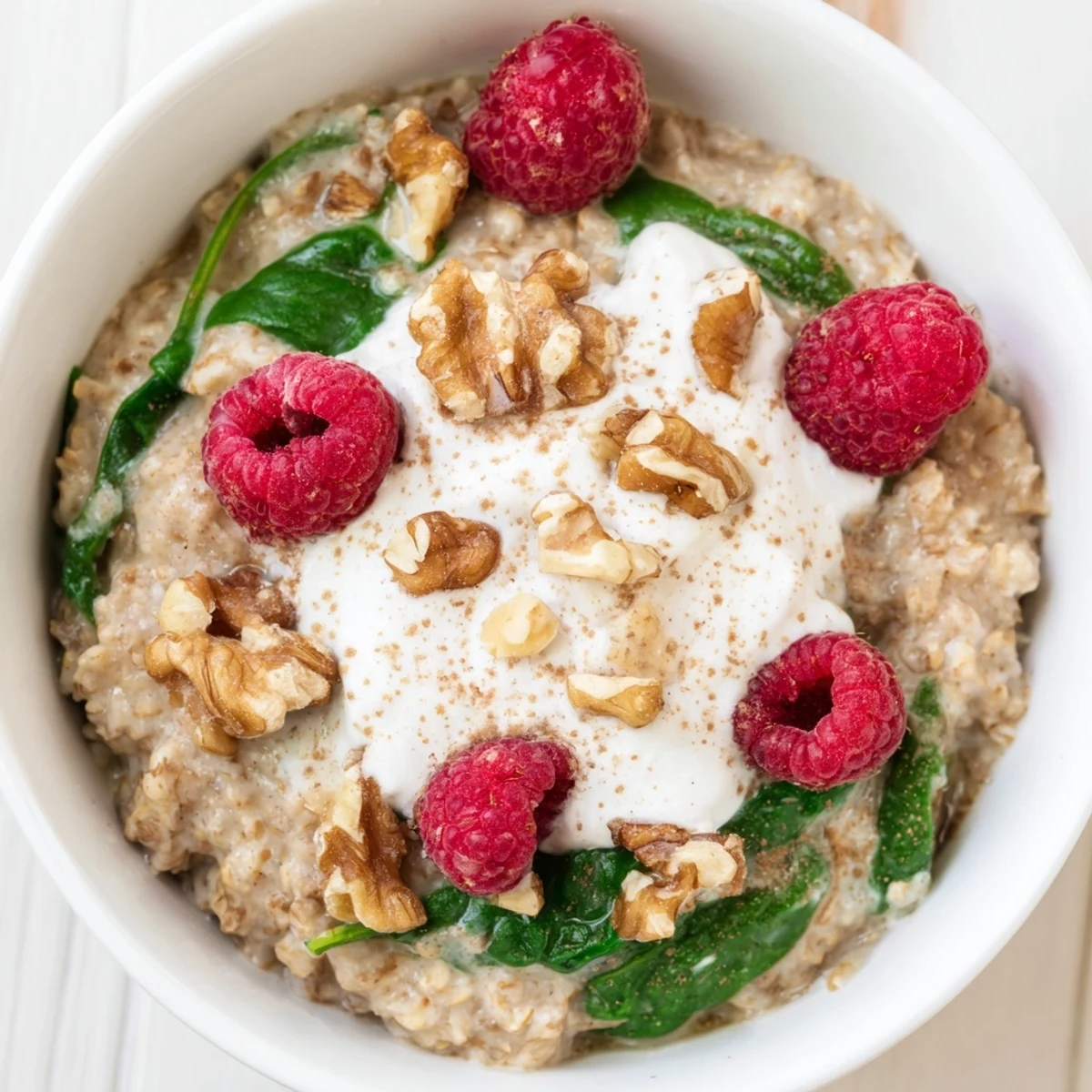 Creamy Frosted Spinach Porridge finished with a frosted yogurt swirl and chopped nuts for a nourishing breakfast.