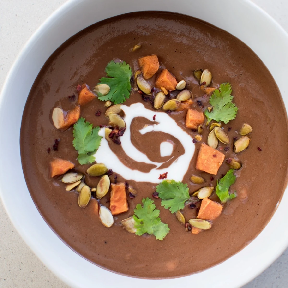 A rich, steamy Seasonal Cacao Soup served with rustic bread for a cozy, comforting meal.