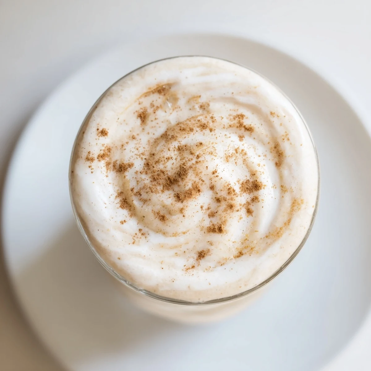 Blending the Frosted Maple Smoothie with ice cubes, creating a thick, frosty, refreshing drink.