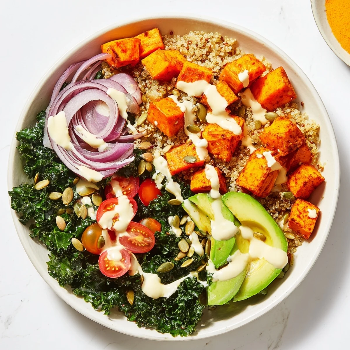 Savor a satisfying vegetarian kale bowl with roasted sweet potatoes, creamy avocado, and toasted pumpkin seeds, finished with a bright lemon-tahini dressing.