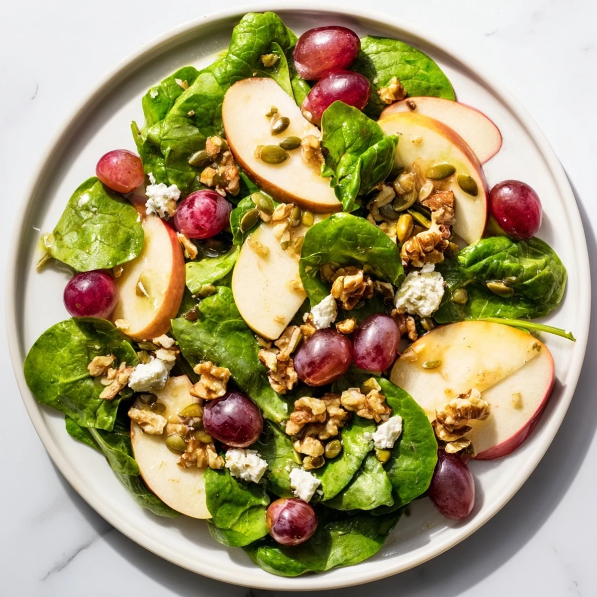 Enjoy a light lunch: the Bright Apple Bowl showcases juicy grapes, nuts, seeds, and a bright, zesty vinaigrette on leafy greens.