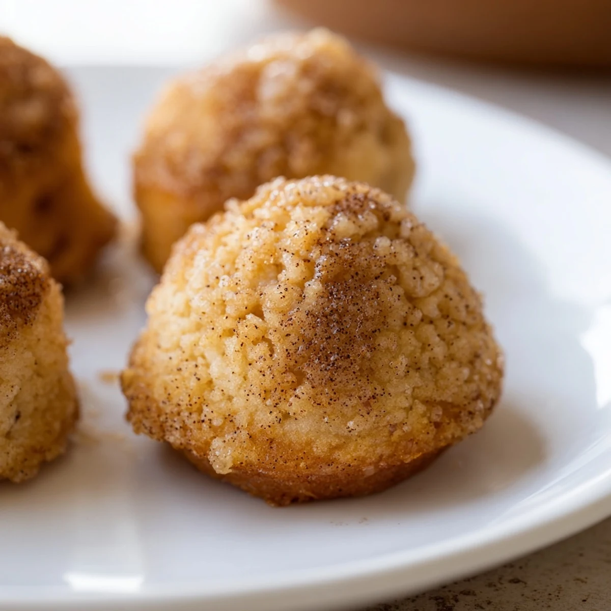 Freshly baked Cozy Maple Bites cooling on a wire rack, their golden tops dusted with powdered sugar.  