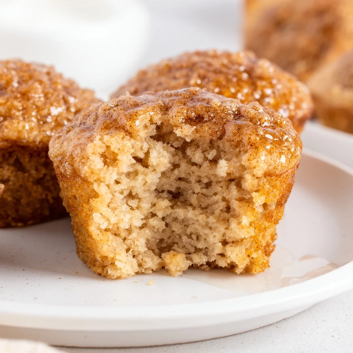 Stack of fluffy Cozy Maple Bites served on a rustic plate with a drizzle of maple syrup.