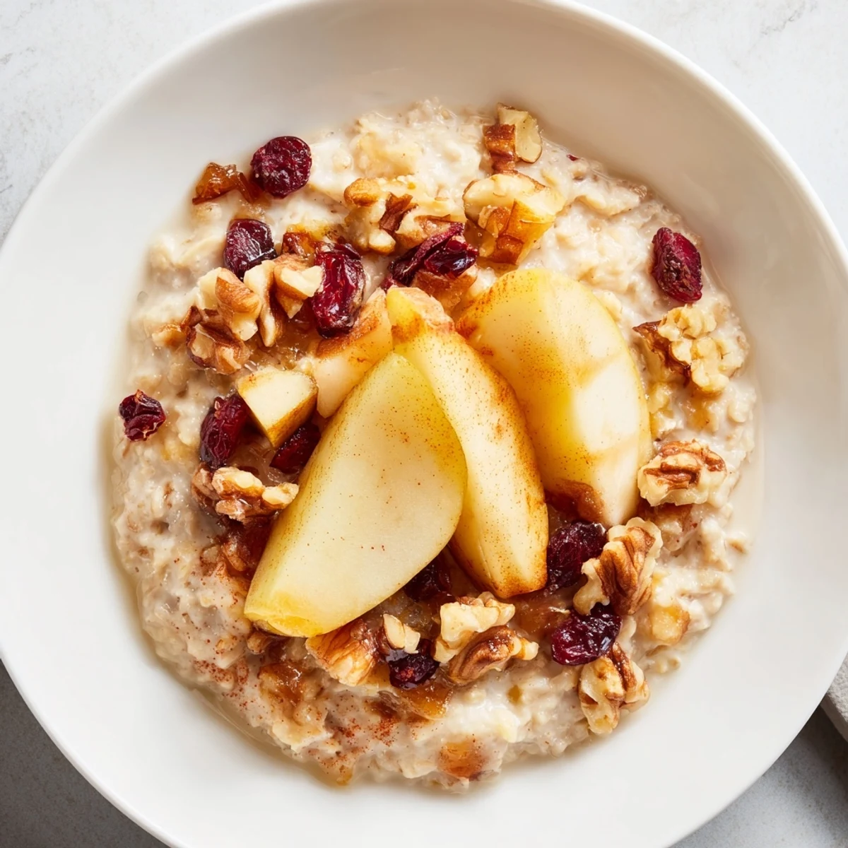 Steaming New Year Pear Porridge with tender pears and a sprinkle of cinnamon in a cozy bowl.