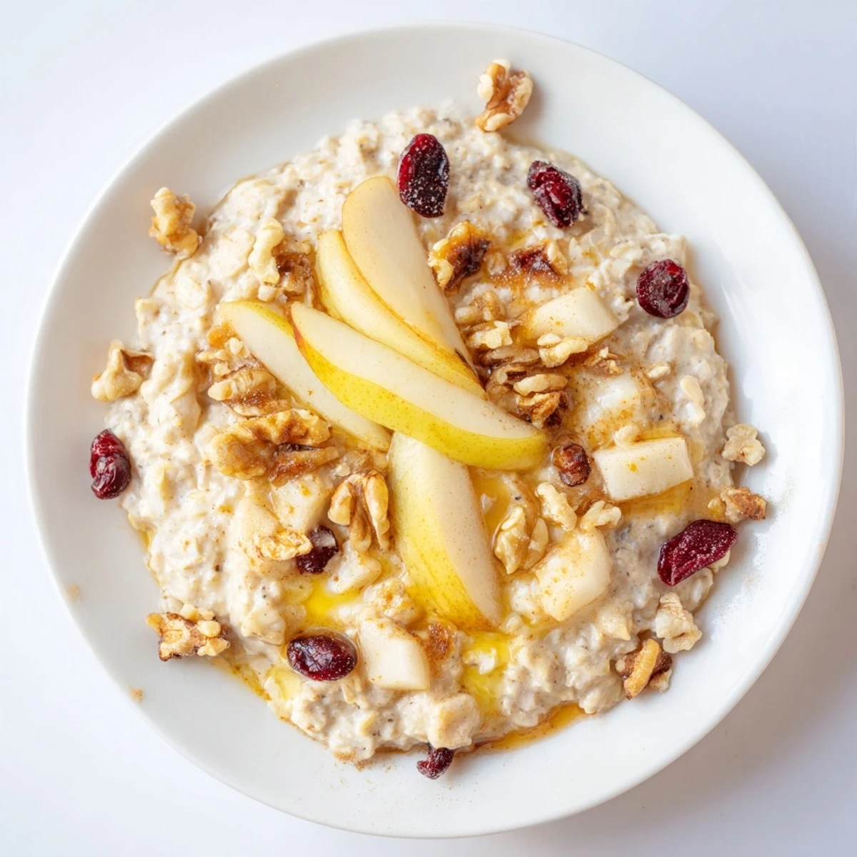 Comforting New Year Pear Porridge served with extra pear slices and a drizzle of maple syrup.