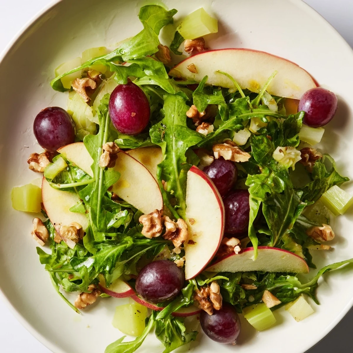 Fresh slices of crisp apples and celery tossed with greens and walnuts in a tangy Vegan Apple Salad.  