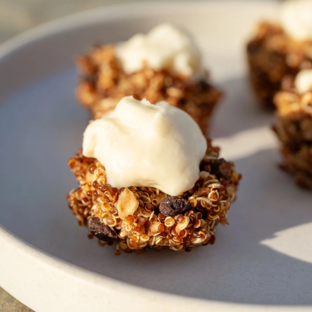 Golden Frosted Quinoa Bites with smooth cream cheese frosting, perfect for a gluten-free treat.