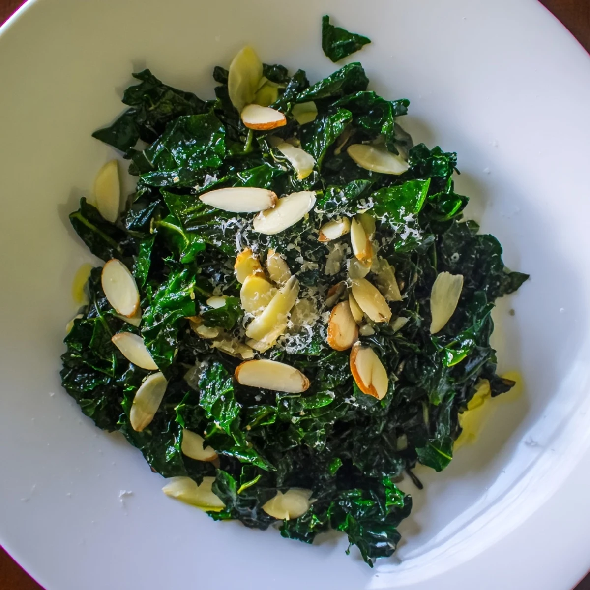 Warm Kale Treat in a skillet, showcasing wilted kale leaves with a hint of lemon juice and savory Parmesan cheese.