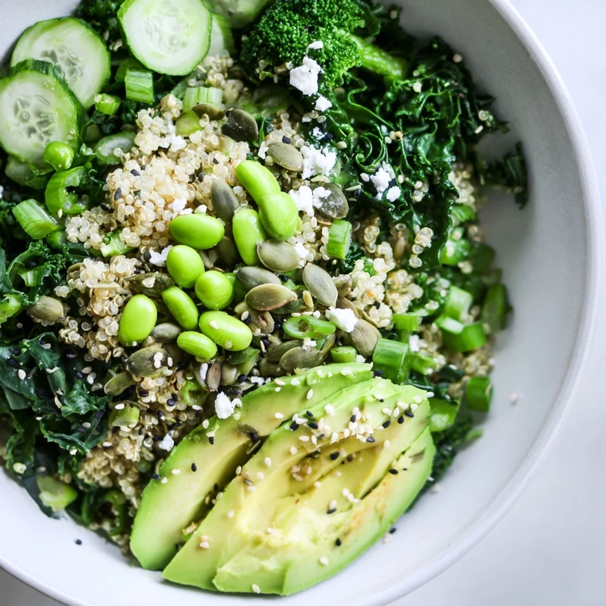Freshly prepared New Year Green Bowl served in a white ceramic bowl, garnished with feta and sesame seeds.