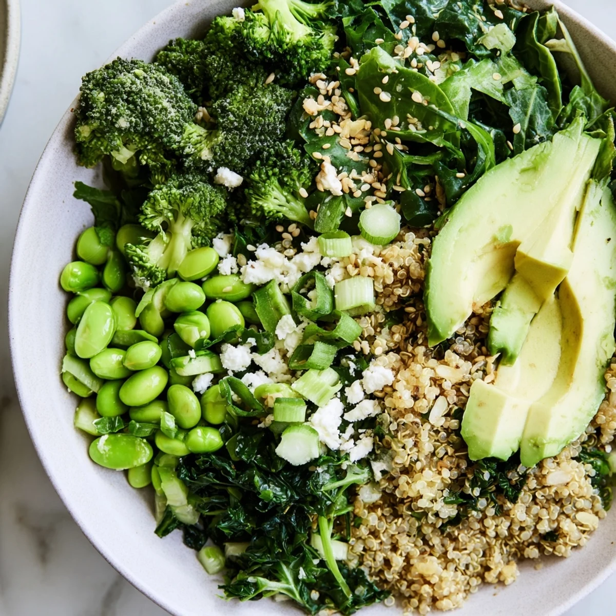 Overhead view of a healthy New Year Green Bowl featuring steamed broccoli, edamame, and a zesty lemon dressing. 
