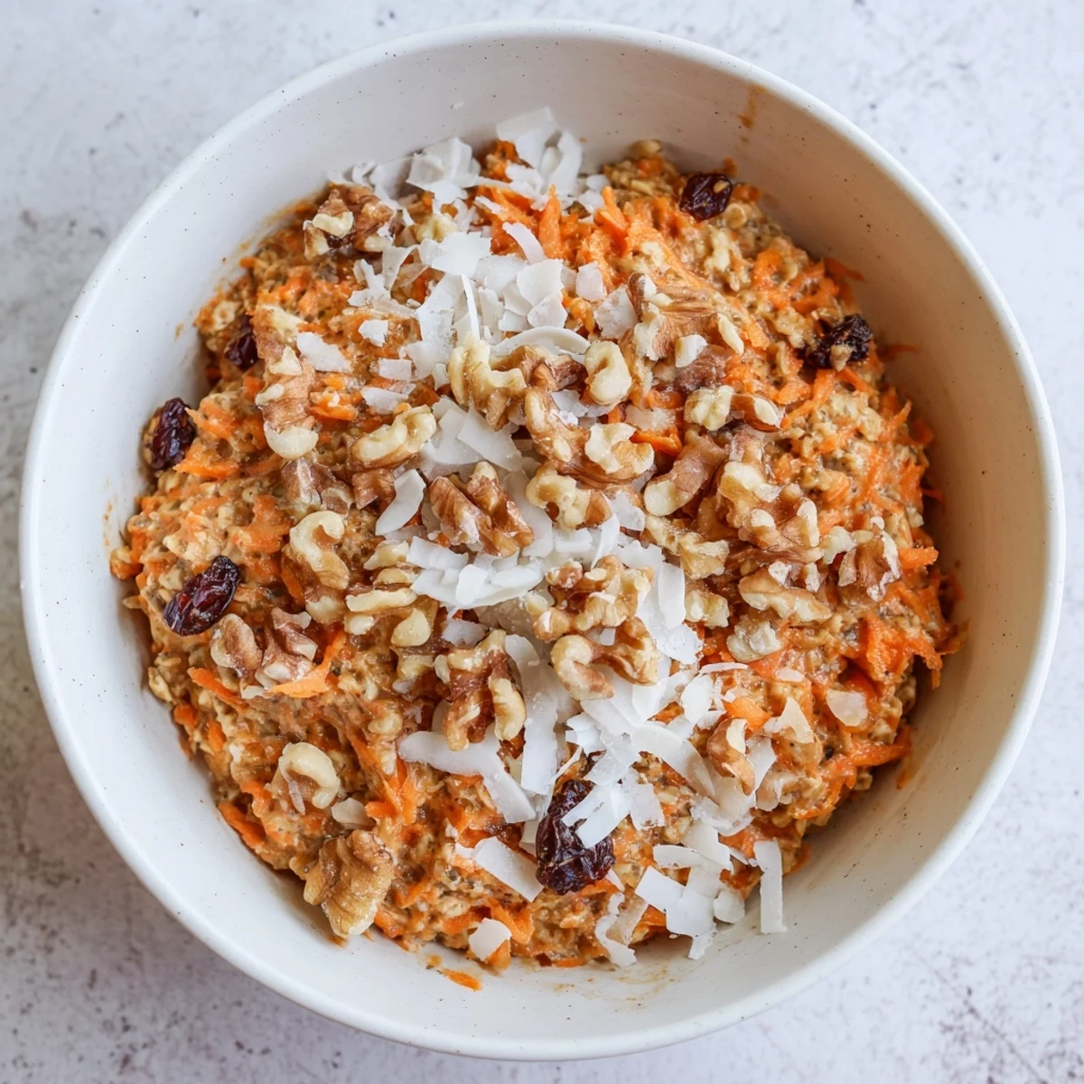 A vibrant Carrot Cake Overnight Oats Breakfast Bowl with warm spices and a drizzle of maple syrup.