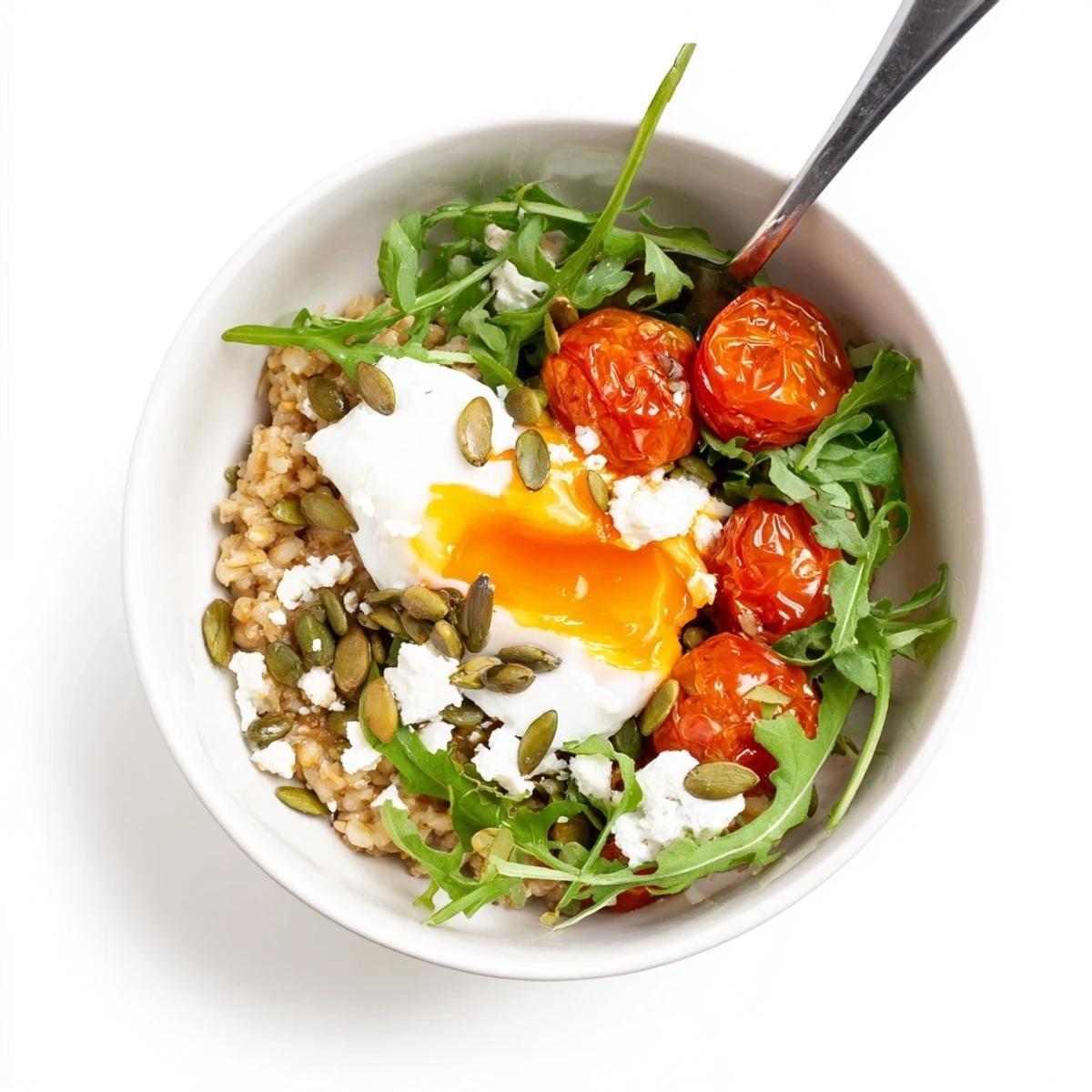 Wholesome Savory Oats Breakfast Bowl with Roasted Tomatoes and Arugula drizzled with olive oil and served next to a steaming mug of coffee.