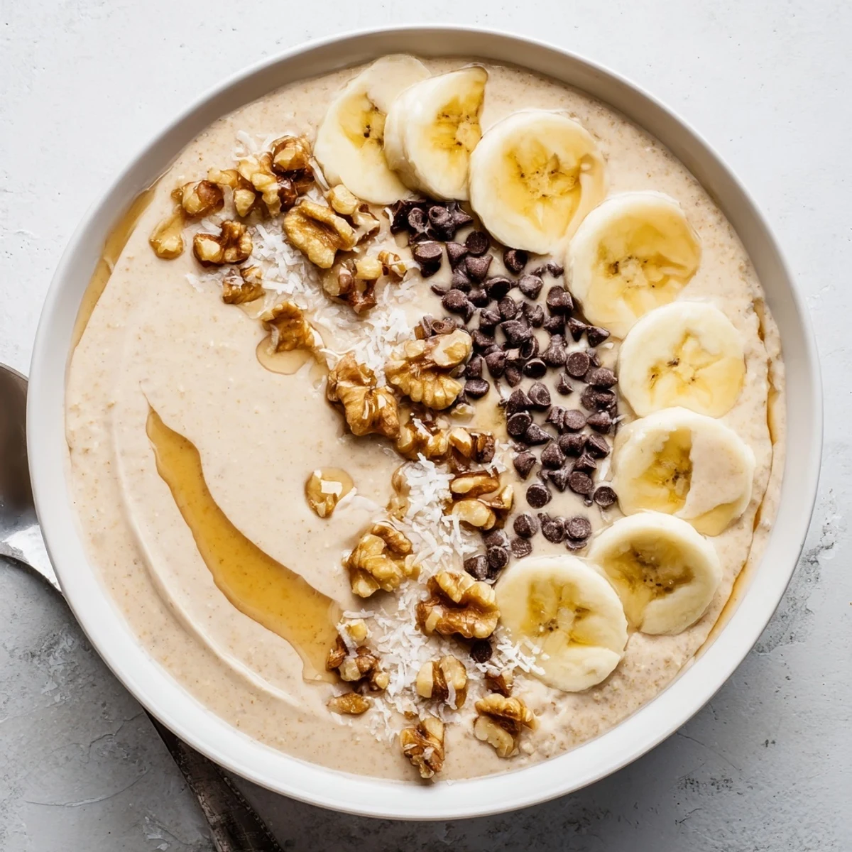 A wholesome Banana Bread Blended Oats Breakfast Bowl with oats, cinnamon, nutmeg, and chocolate chip toppings.