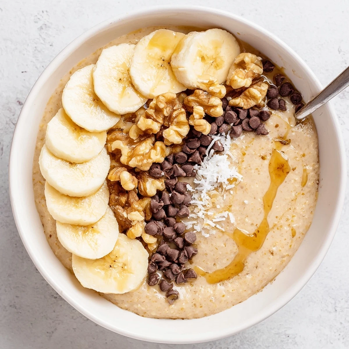 A creamy, spiced Banana Bread Blended Oats Breakfast Bowl served in a cozy ceramic bowl for breakfast.