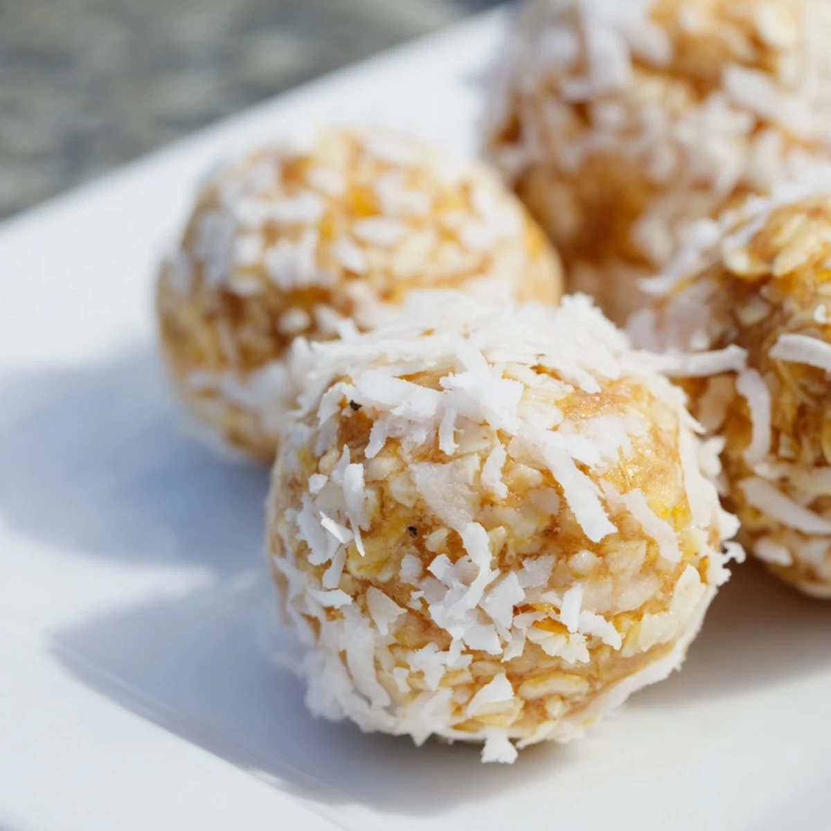 Fresh no-bake lemon coconut bliss balls coated in coconut for healthy snacking