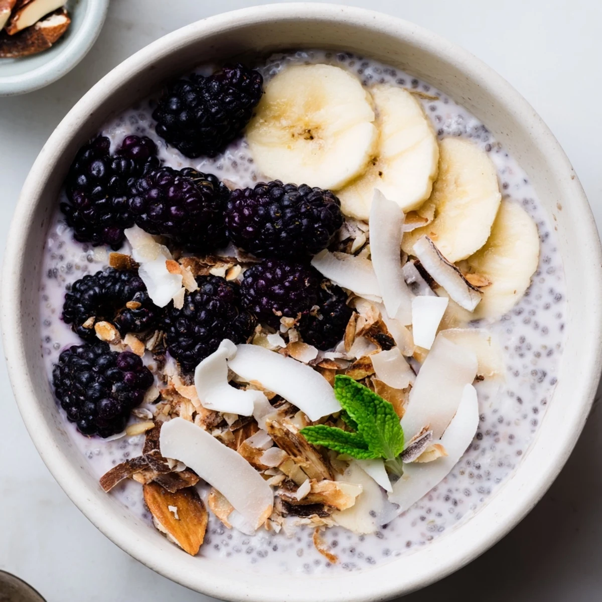 Healthy blackberry vanilla protein chia breakfast bowl layered with fresh fruit and crunchy toppings