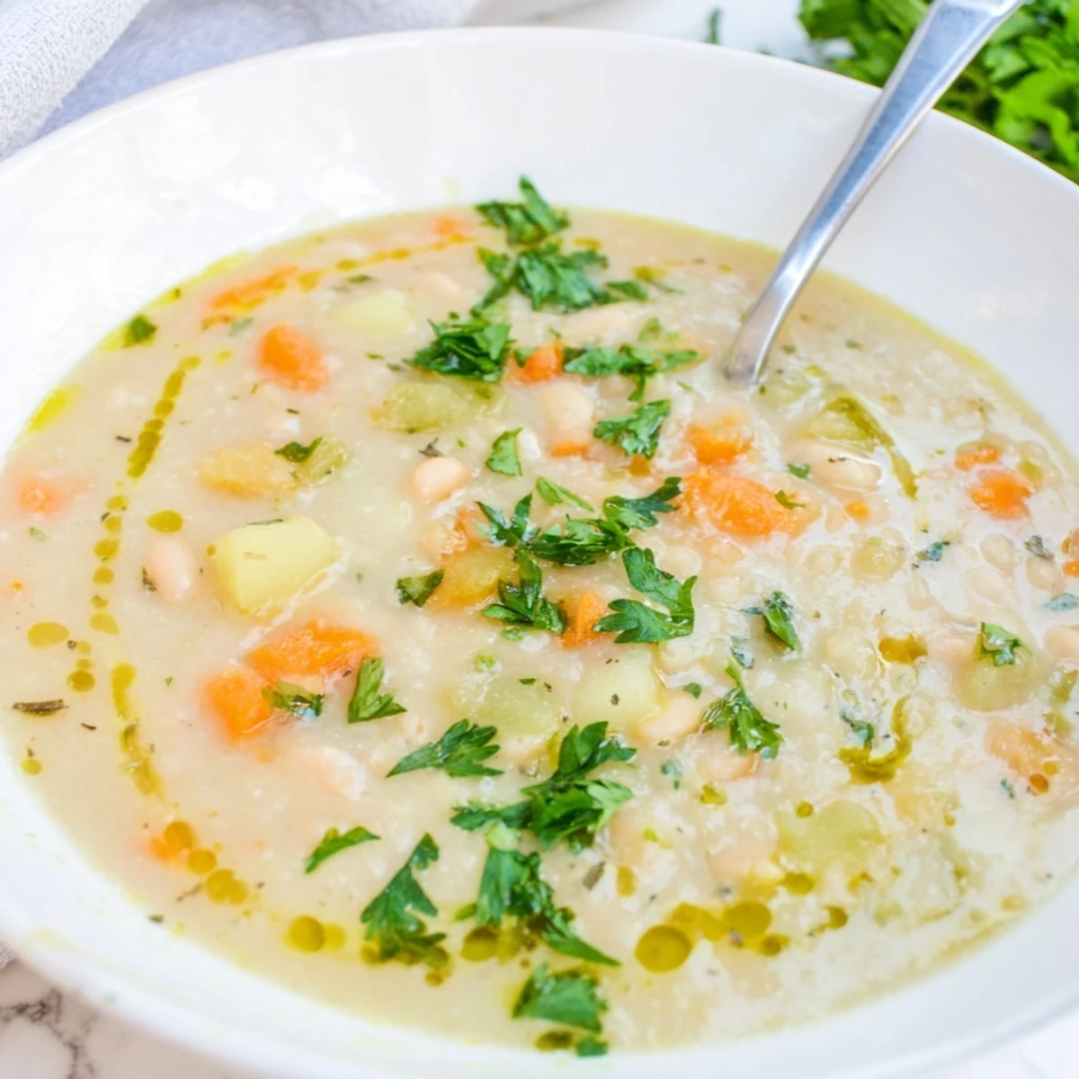 Hearty white bean soup with golden roasted garlic floating in a rustic bowl