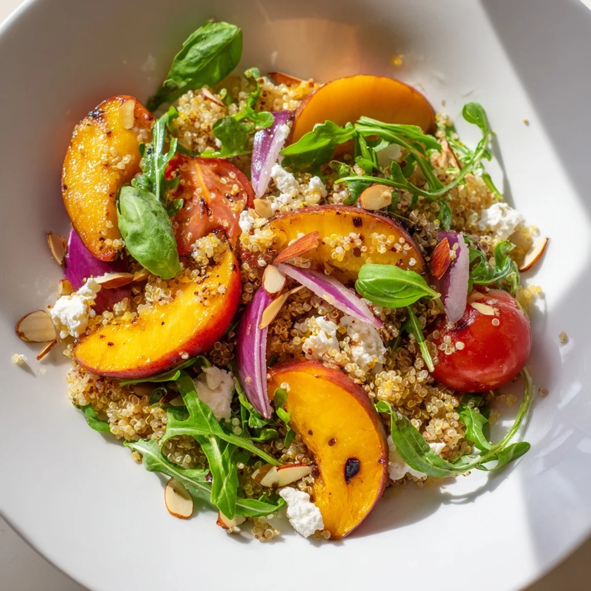 Colorful roasted nectarine and basil quinoa grain salad drizzled with zesty lemon-honey dressing