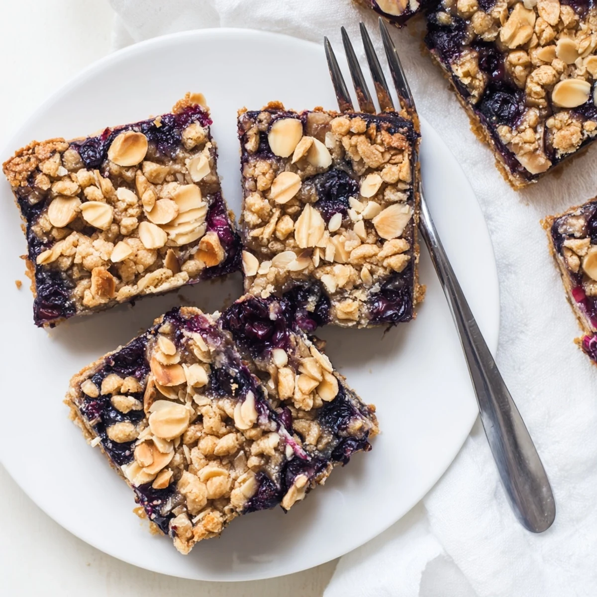 Golden blueberry almond crumble sweet treat bars with bubbling fruit filling and buttery oat topping