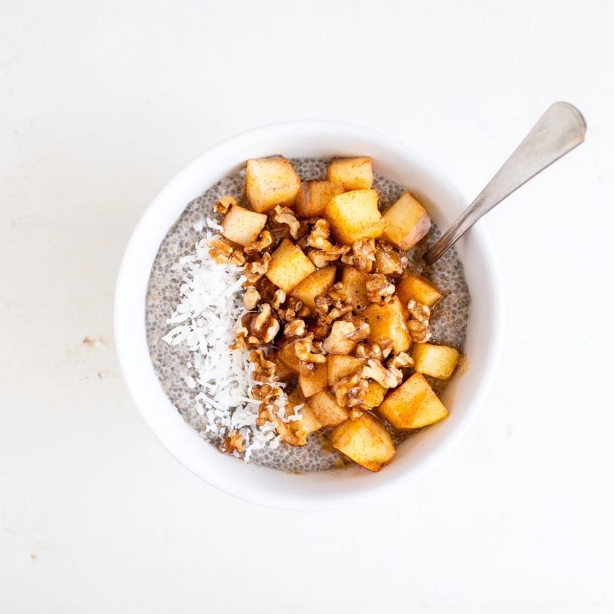 Glass jar layered with cinnamon apple chia overnight breakfast bowl featuring tender diced apples