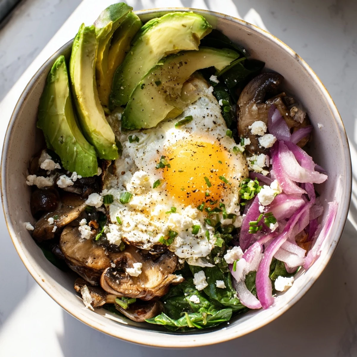 Golden brown spinach and mushroom breakfast bowl topped with a perfectly cooked fried egg