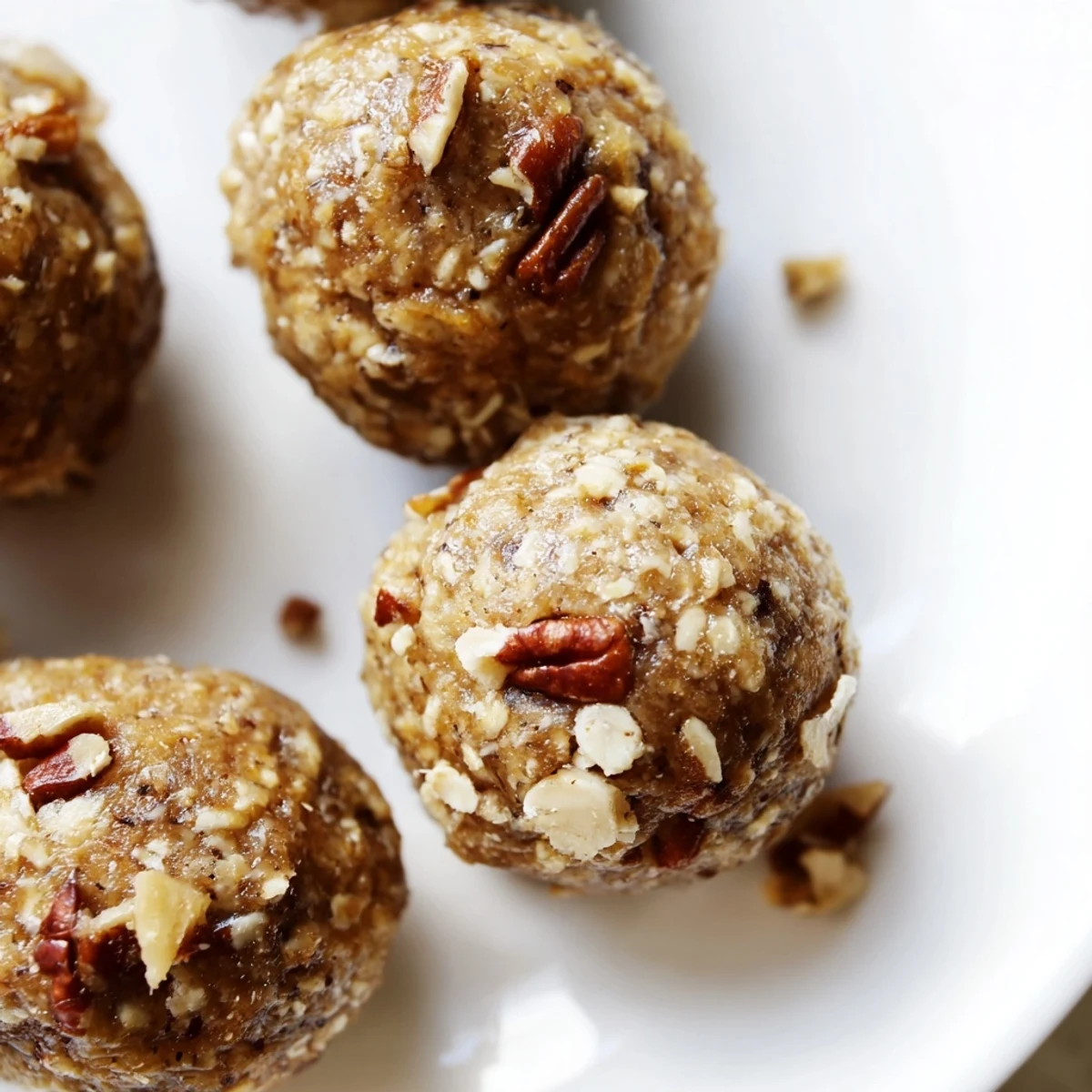 Homemade maple pecan bliss balls arranged on a wooden serving board for healthy snacking