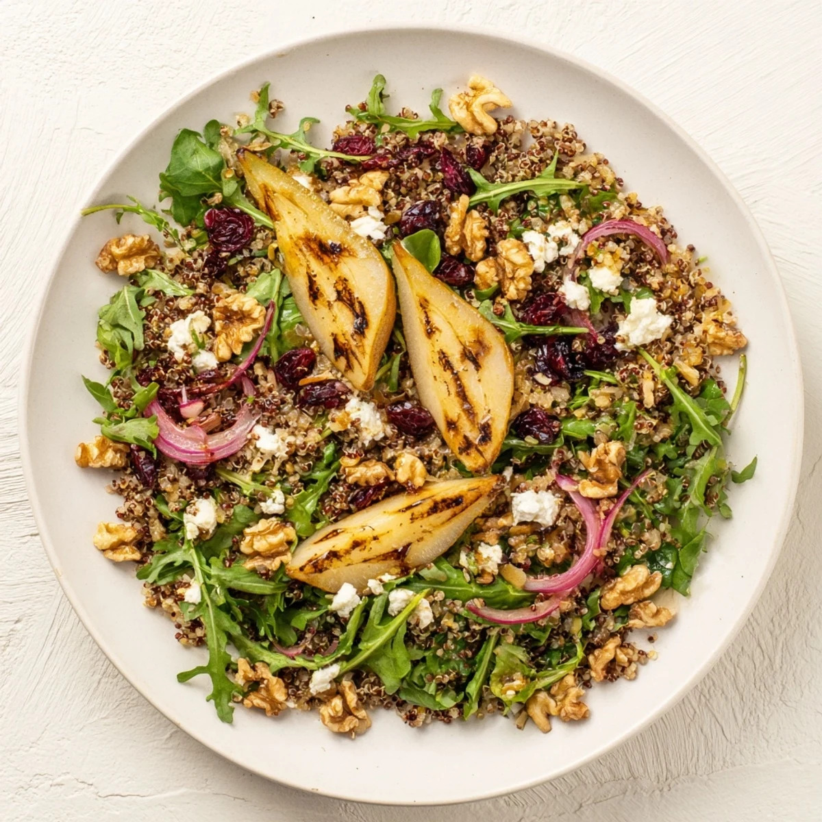 Colorful grilled pear and walnut quinoa grain salad topped with honey lemon dressing