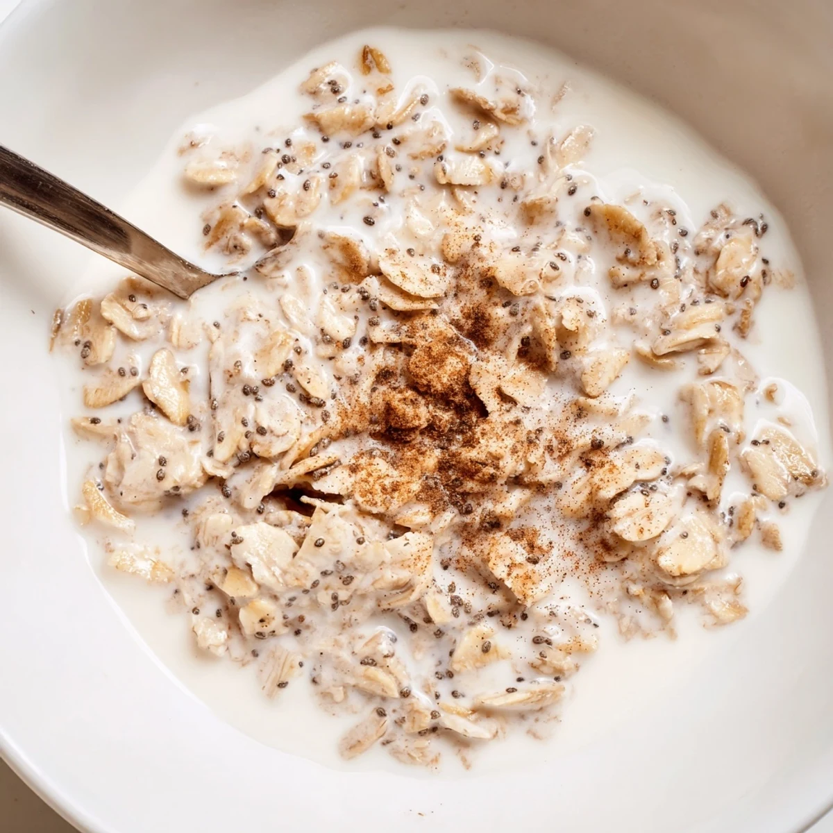 Steaming vanilla fig almond oat breakfast bowl arranged with halved figs, chopped almonds, and honey swirl