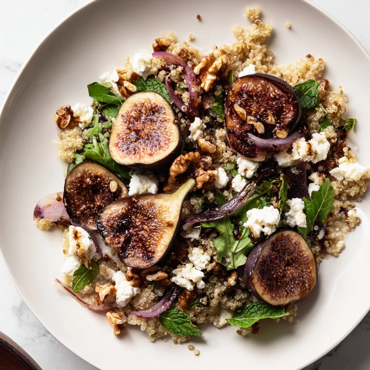 Colorful grilled fig and balsamic quinoa grain salad with fresh arugula and herb garnish