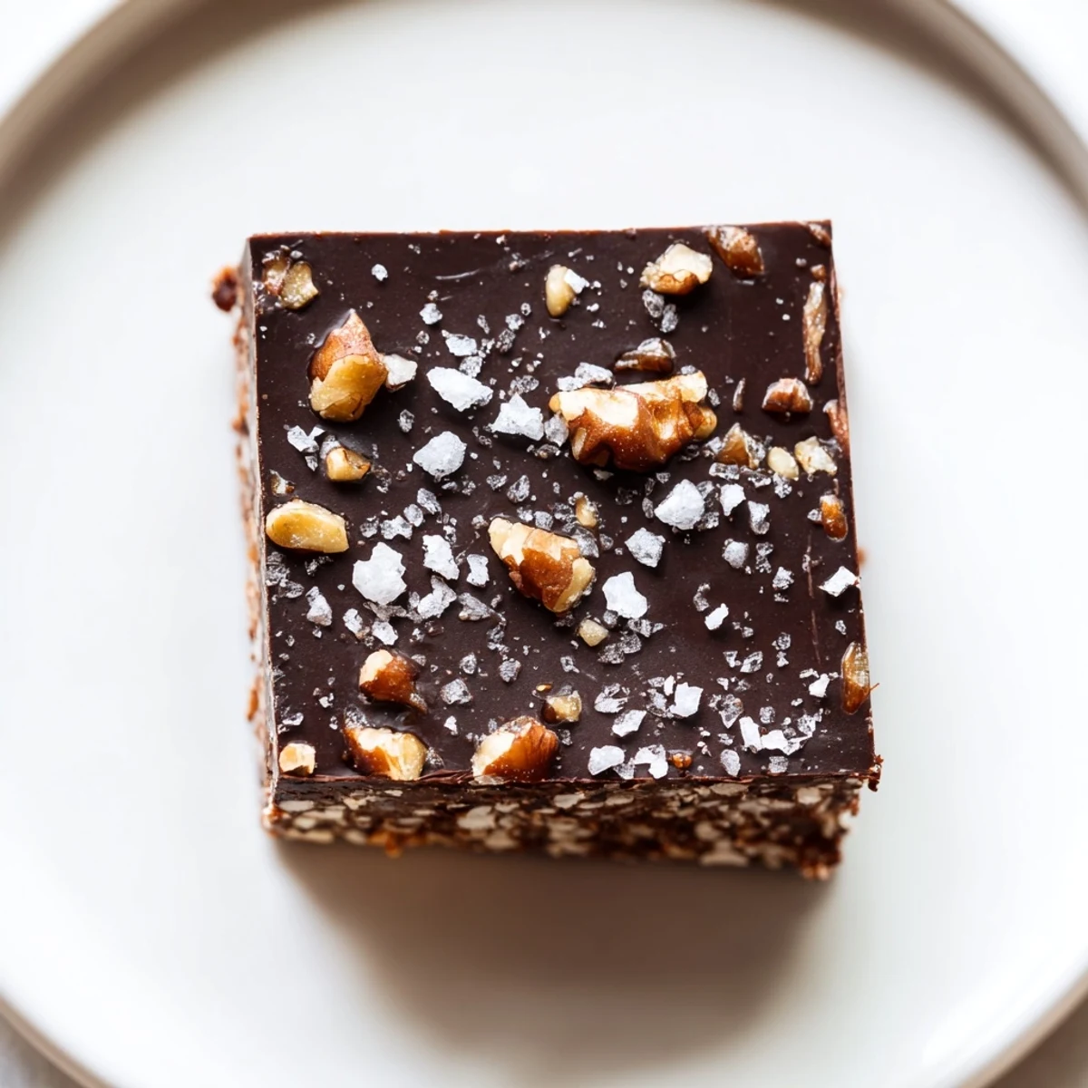Glossy Dark Chocolate Walnut Date Crunch Bars topped with chopped walnuts and flaky sea salt