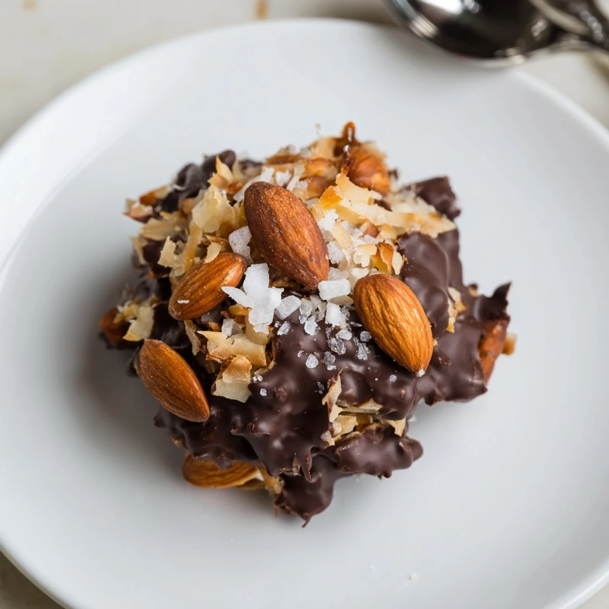Dark Chocolate Almond Coconut Crunch Clusters arranged on parchment, glistening with sea salt