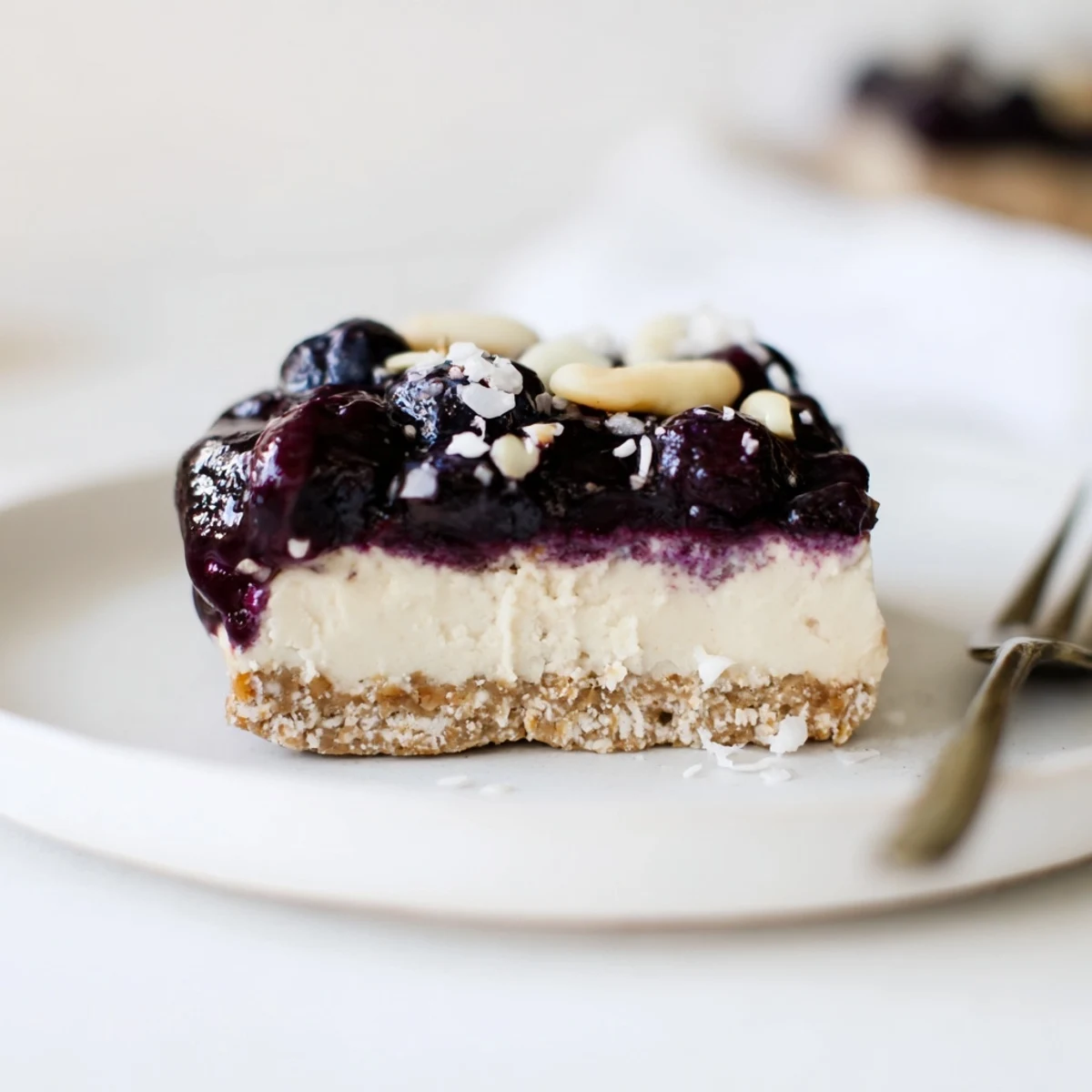 A slice of Blueberry Vanilla Cashew Cream Bars with nutty crust and velvety filling.