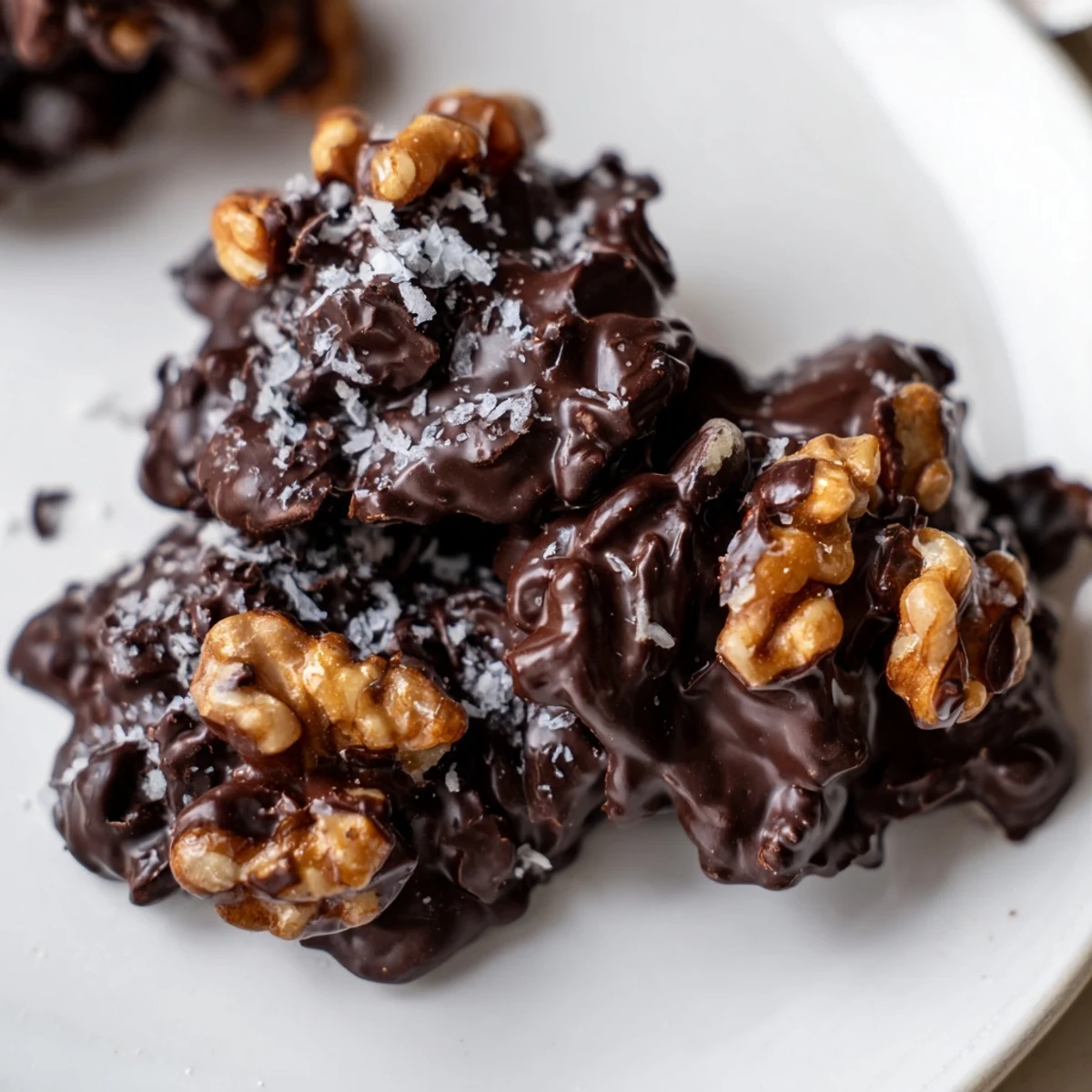 Dark Chocolate Walnut Coconut Clusters glistening with sea salt, chilled on parchment