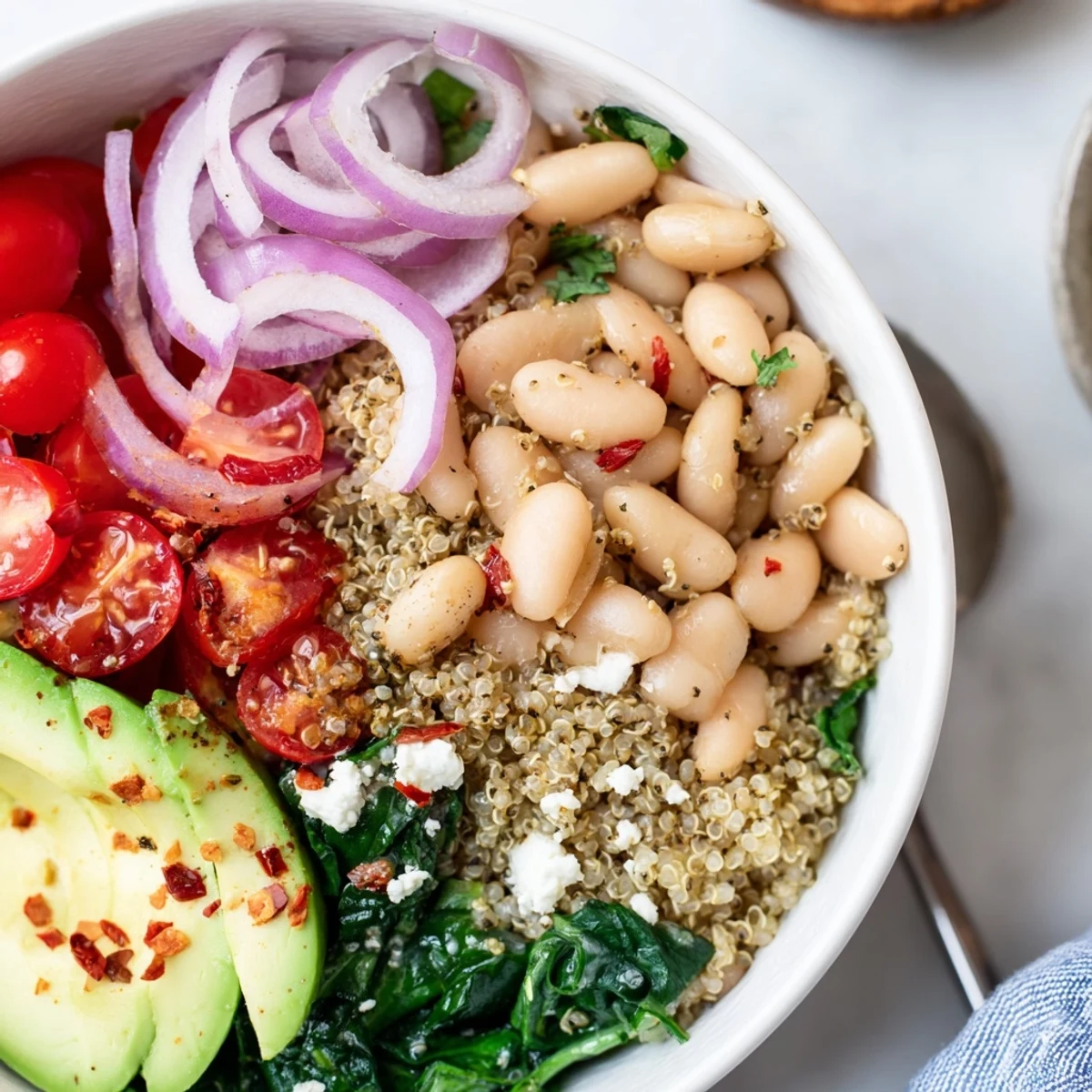 Savory Zaatar White Bean Breakfast Bowl served over quinoa, lemony drizzle, wilted spinach