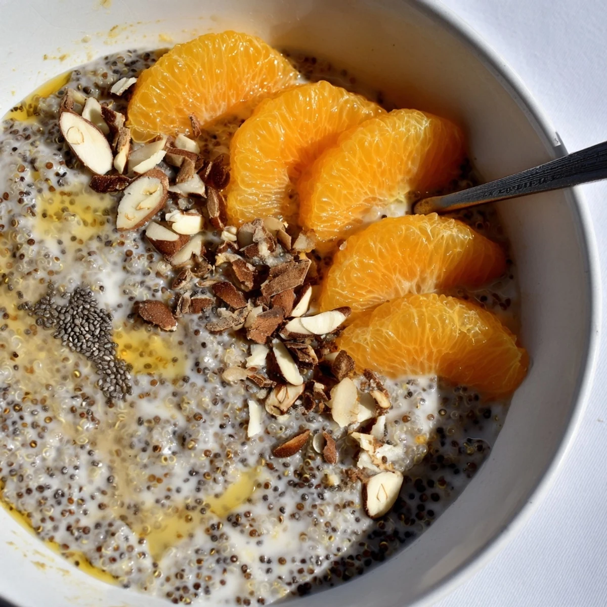 Creamy Vanilla Orange Quinoa Porridge Breakfast Bowl brightened by fresh orange segments  
