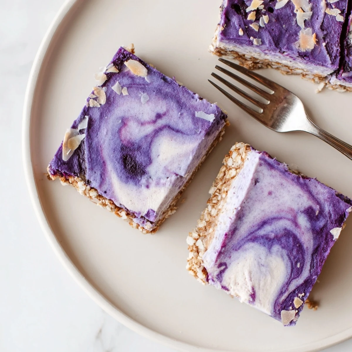 Vibrant blueberry coconut cashew cream bars featuring layered no-bake dessert with purple berry swirl