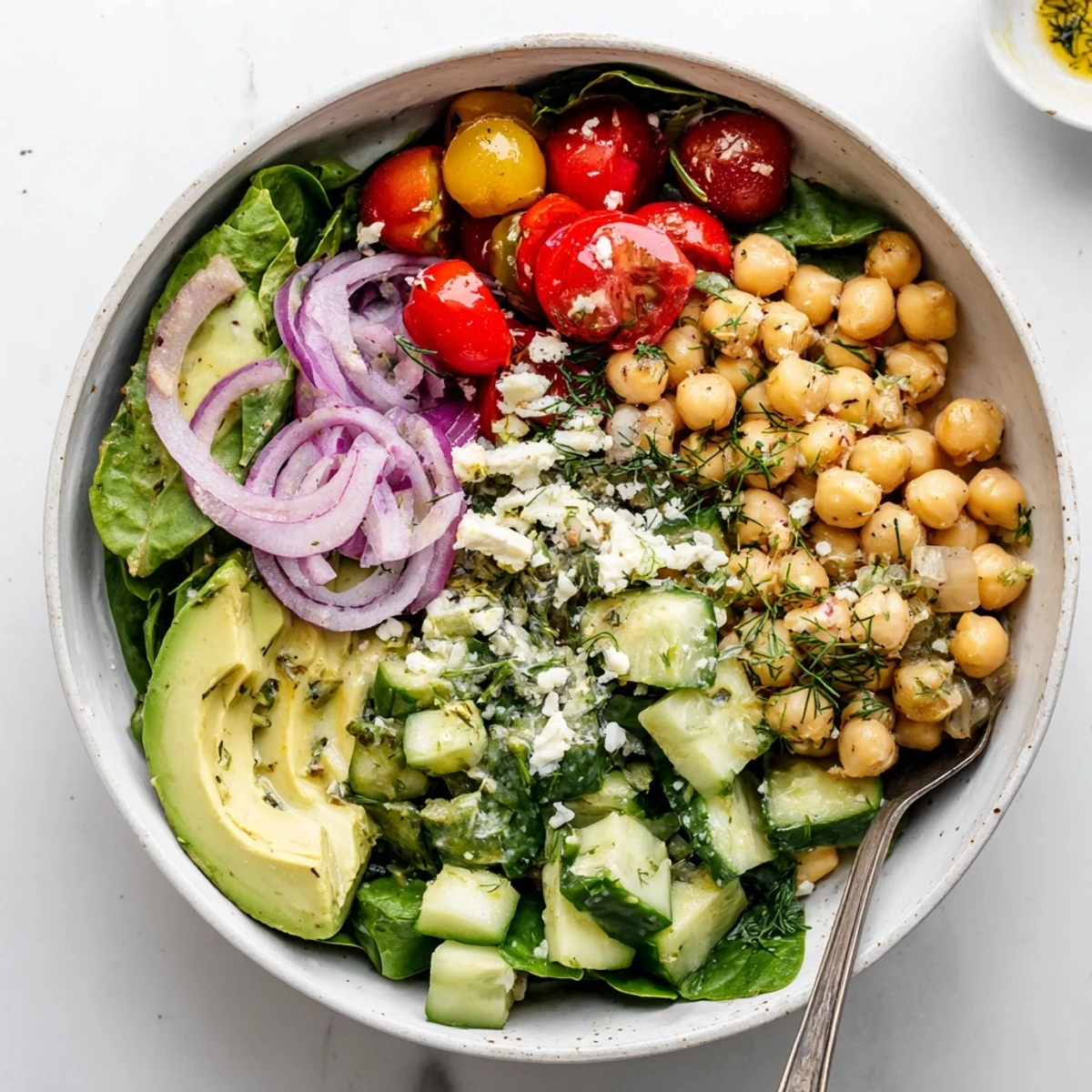 Protein-packed savory lemon dill chickpea bowl served with colorful cherry tomatoes and cucumber slices